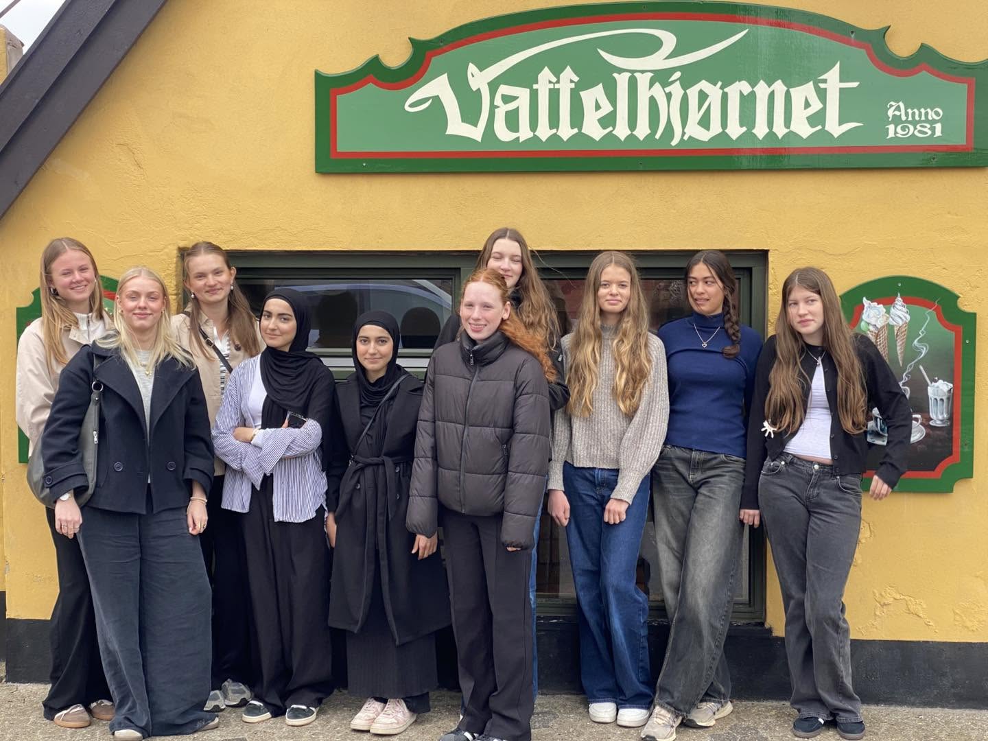 Gruppe gæster foran Vaffelhjørnet-skiltet